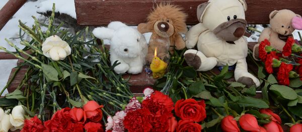 Цветы, свечи и мягкие игрушки возле здания торгового центра Зимняя вишня в Кемерово, где произошел пожар - Sputnik Кыргызстан