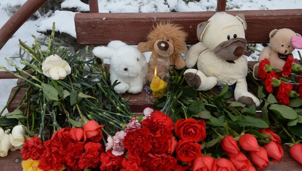 Цветы, свечи и мягкие игрушки возле здания торгового центра Зимняя вишня в Кемерово, где произошел пожар - Sputnik Кыргызстан