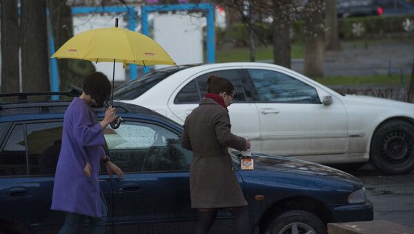 Девушки с зонтом идут по улице во время дождя в Бишкеке. Архивное фото - Sputnik Кыргызстан