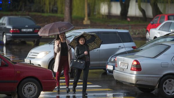Девушки с зонтами переходят дорогу во время дождя. Архив - Sputnik Кыргызстан