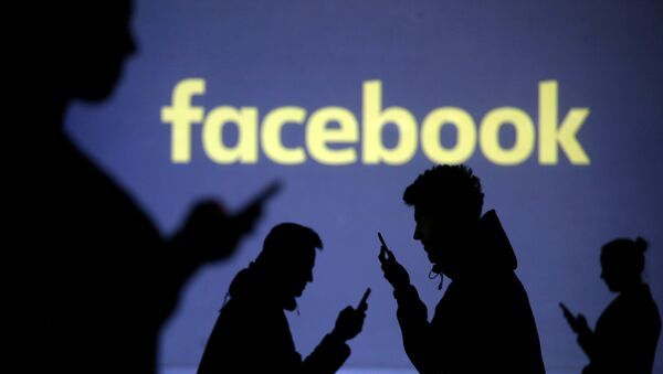 Силуэты людей с телефонами на фоне логотипа социальной сети Facebook. Иллюстративное фото - Sputnik Кыргызстан