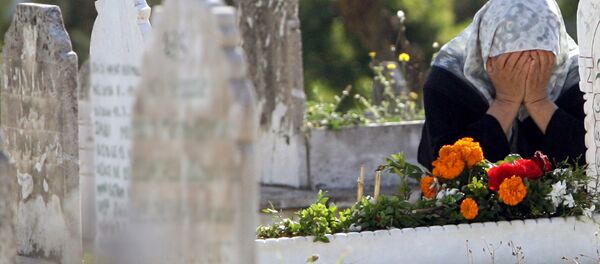 Көрдүн жанында ыйлып жаткан аял. Архив - Sputnik Кыргызстан