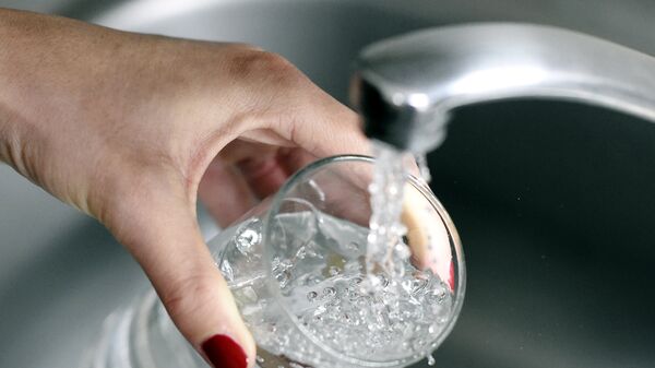 Женщина набирает воду в стакан. Архивное фото - Sputnik Кыргызстан