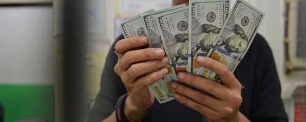 Молодой парень пересчитывает доллары США. Архивное фото - Sputnik Кыргызстан