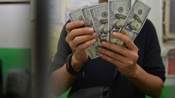 Молодой парень пересчитывает доллары США. Архивное фото - Sputnik Кыргызстан