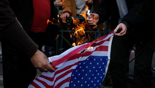Протестующие против воздушных ударов по Сирии военными США, Великобритании и Франции сжигают флаг США - Sputnik Кыргызстан