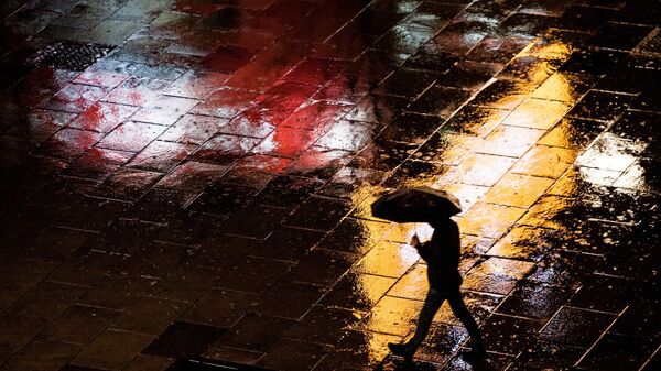 Мужчина с зонтом идет по улице во время дождя. Архивное фото - Sputnik Кыргызстан