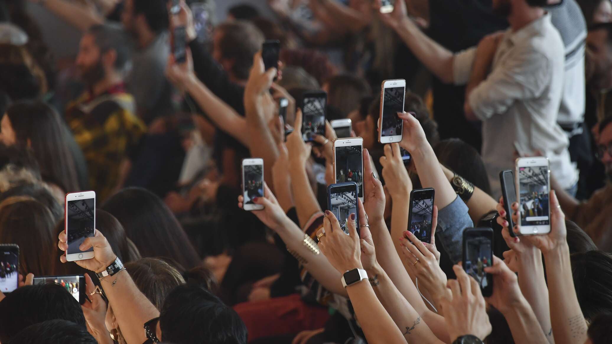 Демонстрация смартфона. Много людей с айфонами. Человек со смартфоном в руке. Много людей с мобильниками. Толпа людей с айфонами.
