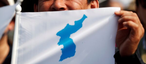 Түндүк жана Түштүк кореянын бириккен картасын кармап турган адам. Архив Түндүк жана Түштүк кореянын бириккен картасын кармап турган адам. Архив - Sputnik Кыргызстан