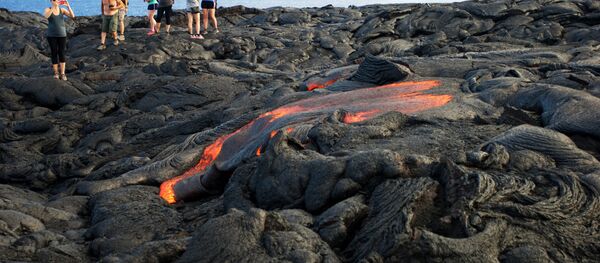 Туристы фотографируются на фоне вулканической лавы. Архивное фото - Sputnik Кыргызстан