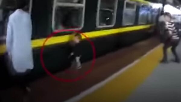 В Китае девочка упала под поезд, ее успели вытащить — видео спасения - Sputnik Кыргызстан