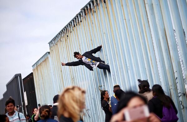 Тихуандагы Мексика менен АКШнын чек ара дубалында турган Борбордук Америкалык мигранттар - Sputnik Кыргызстан