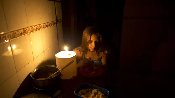 Девушка во время отключения света сидит в темноте. Архивное фото - Sputnik Кыргызстан