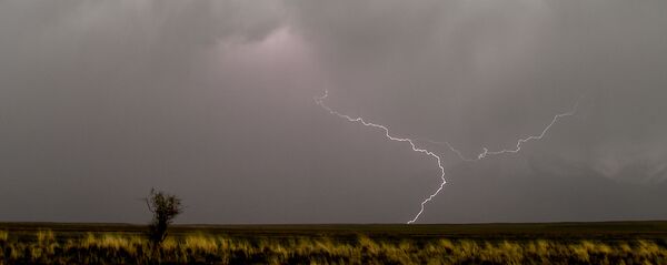 Молния во время грозы около горы Кызыл-Бел, в Ат-Баши, примерно в 350 км от Бишкека. Архивное фото - Sputnik Кыргызстан