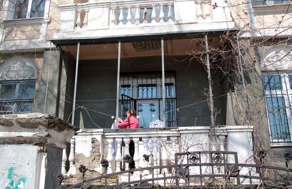 Центр города. Женщина развешивает белье на балконе старинной усадьбы. - Sputnik Кыргызстан