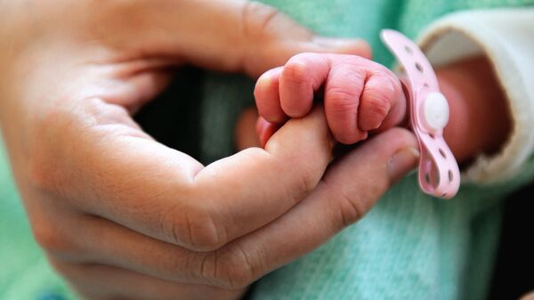 Новорожденный ребенок держится за руку матери. Архивное фото - Sputnik Кыргызстан