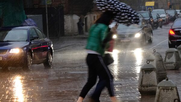 Пешеходы на улице во время сильного дождя. Архивное фото - Sputnik Кыргызстан