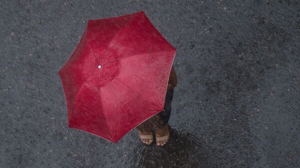 Женщина с зонтом во время сильного дождя. Архивное фото - Sputnik Кыргызстан