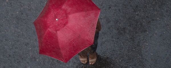 Женщина с зонтом во время сильного дождя. Архивное фото - Sputnik Кыргызстан
