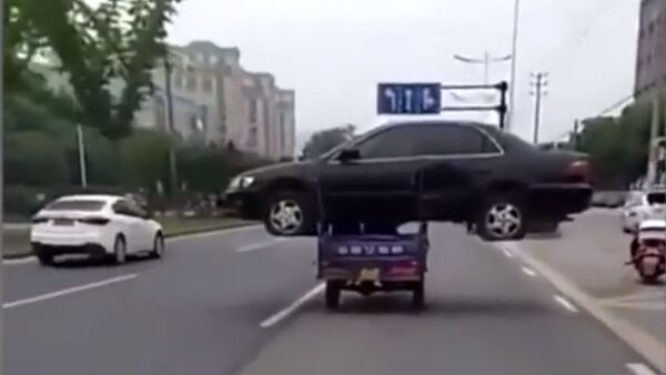 Вы не поверите, но так можно: китаец везет авто на мотороллере. Видео - Sputnik Кыргызстан
