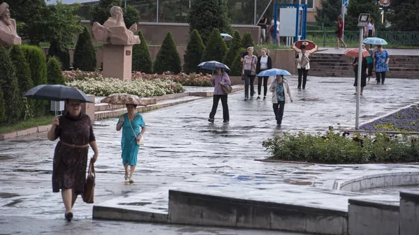 Горожане с зонтами на аллее молодежи в Бишкеке во время дождя. Архивное фото  - Sputnik Кыргызстан