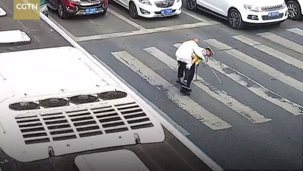 Пенсионер с трудом переходил дорогу, полицейский перенес его на себе. Видео - Sputnik Кыргызстан
