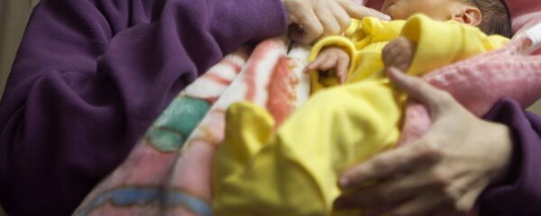 Женщина с новорожденным ребенком в руке. Архивное фото - Sputnik Кыргызстан