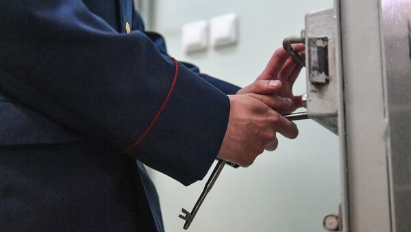 Сотрудник следственного изолятора закрывает замок на ключ. Архивное фото - Sputnik Кыргызстан
