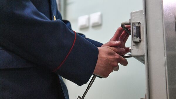 Сотрудник следственного изолятора закрывает замок на ключ. Архивное фото - Sputnik Кыргызстан