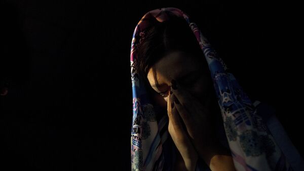 Девушка в платке плачет в темной комнате. Иллюстративное фото - Sputnik Кыргызстан
