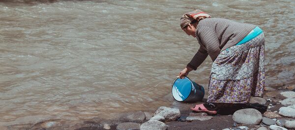 Женщина набирает воду из реки. Архивное фото - Sputnik Кыргызстан