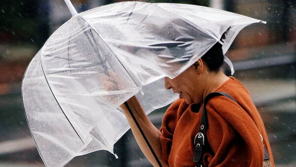 Женщина во время сильного ветра с зонтом в руках. Архивное фото - Sputnik Кыргызстан