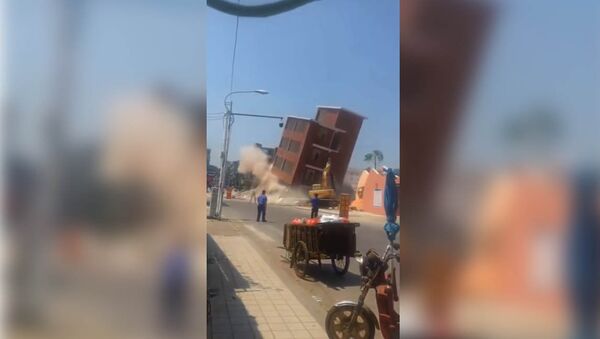 В Китае многоэтажный дом рухнул на экскаватор, машинист чудом выжил. Видео - Sputnik Кыргызстан