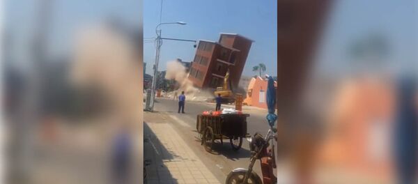 В Китае многоэтажный дом рухнул на экскаватор, машинист чудом выжил. Видео В Китае многоэтажный дом рухнул на экскаватор, машинист чудом выжил. Видео - Sputnik Кыргызстан