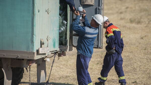 Сотрудники ОАО Национальная электрическая сеть Кыргызстана во время замены старых изоляторов . Архивное фото - Sputnik Кыргызстан