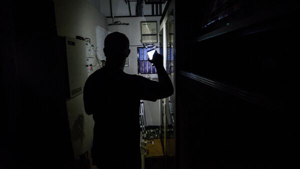 Мужчина с фонариком у электрощитка. Архивное фото - Sputnik Кыргызстан