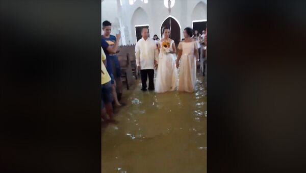 Не помешало даже наводнение — пара обвенчалась в затопленной церкви. Видео - Sputnik Кыргызстан