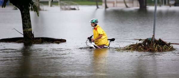 Женщина с велосипедом на одной из улиц затопленных ураганом в городе Хило (Гавайи). Архивное фото - Sputnik Кыргызстан