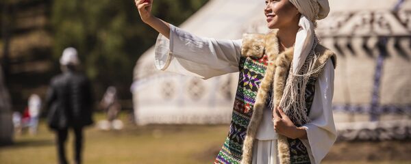 Девушка в национальной одежде делает селфи. Архивное фото Девушка в национальной одежде делает селфи. Архивное фото - Sputnik Кыргызстан