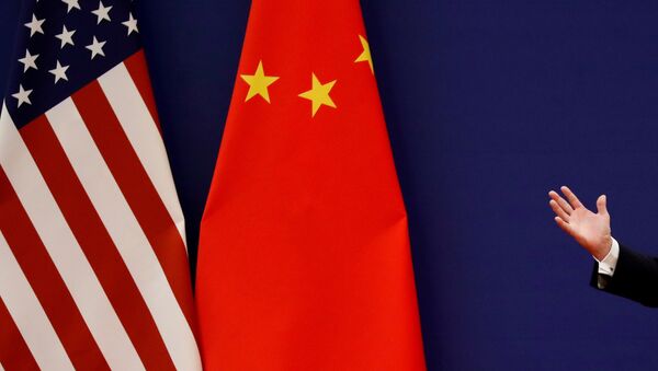 Рука человека на фоне флагов США и Китая. Архивное фото - Sputnik Кыргызстан