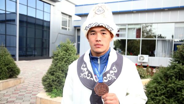 Бүгүн, 21-сентябрда Ош эл аралык аэропортунан грек-рим күрөшү боюнча жаштар арасында өткөн Дүйнө чемпионатынан байгелүү кайткан Акжол Махмудовду эл тосуп алды - Sputnik Кыргызстан