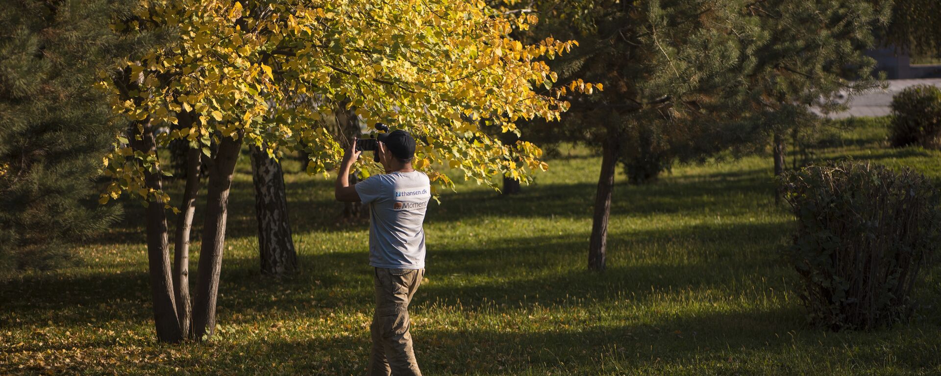 Мужчина фотографирует деревья в Бишкекском парке на телефон. Архивное фото - Sputnik Кыргызстан, 1920, 11.09.2023