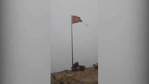 На горе близ Бишкека порвался флаг Кыргызстана, кругом снег. Видео - Sputnik Кыргызстан