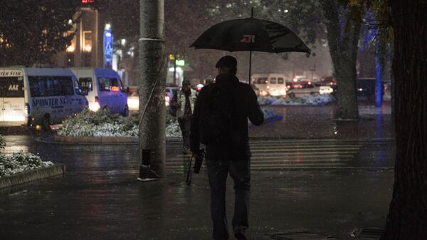 Мужчина идет по улице с зонтом в снегопад. Архивное фото  - Sputnik Кыргызстан