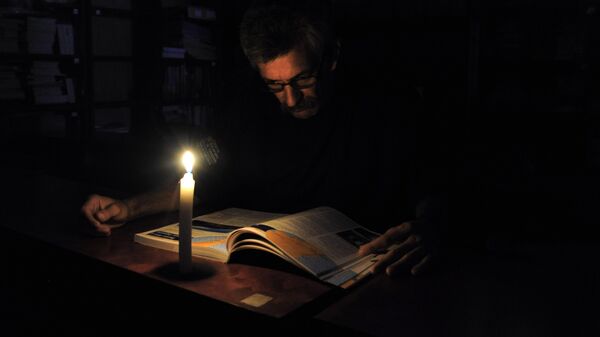 Человек читает журнал во время отключения света. Архивное фото - Sputnik Кыргызстан