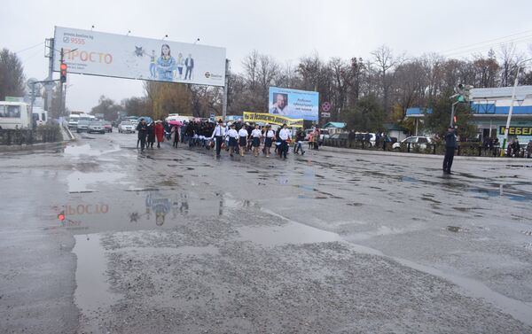 На кадрах видно, что шествие возглавили шестеро школьников в рубашках с коротким рукавом, а девочки маршировали в юбках - Sputnik Кыргызстан