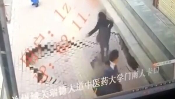 Девушка неожиданно провалилась под асфальт в Китае — страшное видео - Sputnik Кыргызстан