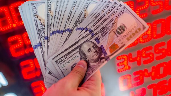 Мужчина показывает долларовые банкноты в пункте обмена валюты. Архивное фото - Sputnik Кыргызстан