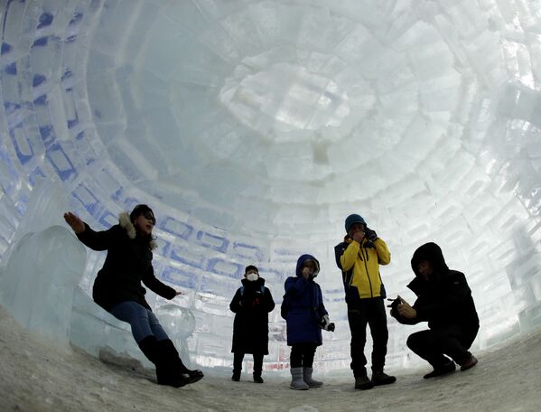 Люди фотографируются в иглу, построенном для зимних Олимпийских игр 2018 года в Пхенчхане (Южная Корея) - Sputnik Кыргызстан