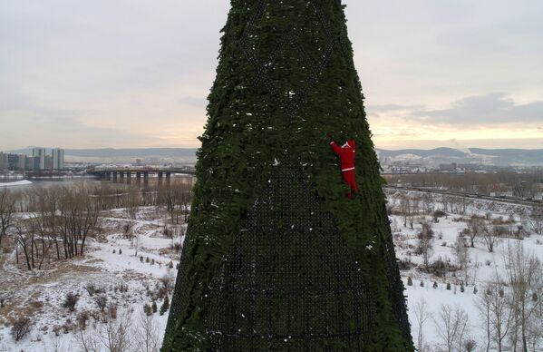 Красноярск шаарында Аяз атанын костюмун кийген альпинист 57 метрлик балатыны кооздоп жатат - Sputnik Кыргызстан